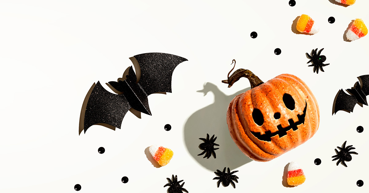 Cartoon bat and jack-o-lantern on a white background surrounded by candy corn and bat graphics